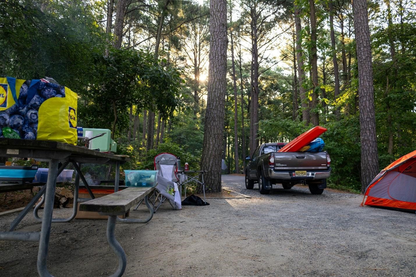 A truck parked next to a tent in the woods